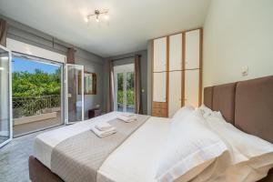 a bedroom with a large bed and a balcony at Popi's apartment in Argostoli +24 photos