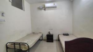 a room with two beds and a tv in it at Radhe Krishna Guest House in Srīrangam +21 photos