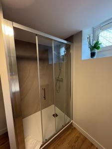 a shower stall in a room with a window at Le prélong in Murol