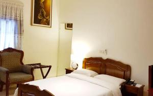 a bedroom with a bed and a chair in it at Hôtel Cauris d'Or de Bouaké in Bouaké