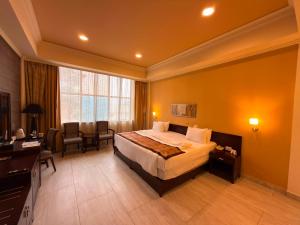 a large hotel room with a bed and a desk at Royal Grand Hotel in Monrovia +27 photos