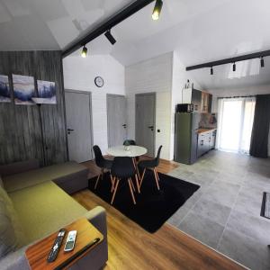 a living room with a table and a kitchen at OLENEVO Park Houses in Olenʼovo