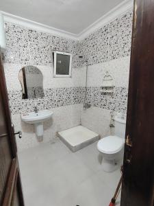 a white bathroom with a toilet and a sink at شقة14 in Irbid