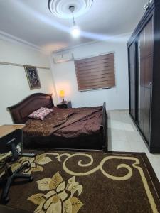a bedroom with a bed and a rug on the floor at شقة14 in Irbid