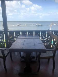 a wooden table and chairs on a balcony overlooking the ocean at Lamu Sunsail Hotel in Lamu