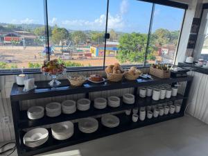 a shelf filled with white plates and bowls of food at Hotel Omega in Oiapoque
