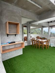 a dining room with a table and green grass at Silvan Garden Retreat in Tanah Rata