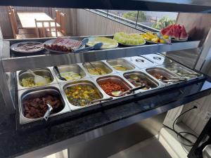 a buffet line with many trays of food at Hotel Omega in Oiapoque +5 photos