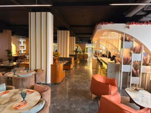 a restaurant with tables and chairs and a lobby at Royal Grand Hotel in Monrovia