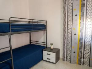 a bedroom with two bunk beds and a night stand at Andasì in Pachino