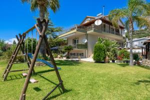 a swing in a yard in front of a house at Popi's apartment in Argostoli