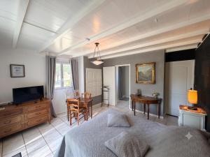 ein Schlafzimmer mit Bett, Schreibtisch und Fernseher in der Unterkunft L'Ariade in Monpazier