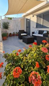 a patio with a bunch of flowers and furniture at Andasì in Pachino