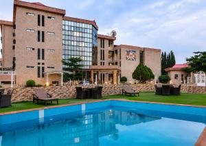 a hotel with a swimming pool in front of a building at Aneks Ibro Hotel, Wuse Zone 5, Abuja in Abuja