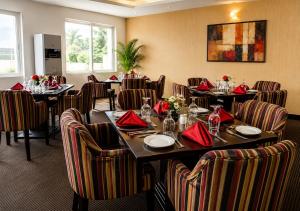 a dining room with tables and chairs with red napkins at Aneks Ibro Hotel, Wuse Zone 5, Abuja in Abuja