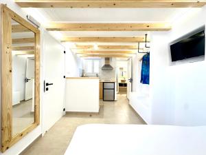 a kitchen with white walls and wooden ceilings at Sul Mare Suite in Agia Kiriaki Beach