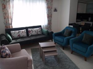 een woonkamer met een bank, 2 stoelen en een tafel bij Orion Resort Zara 20 in Avsallar