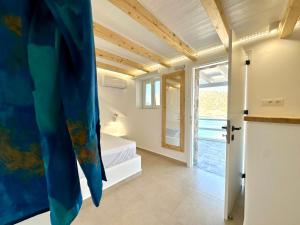 a room with a bed and a bathroom with a window at Sul Mare Suite in Agia Kiriaki Beach