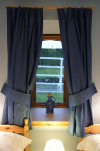 una ventana con cortinas azules en un dormitorio en Shegarton Farm Cottages, en Luss