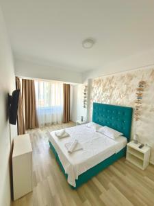 a bedroom with a blue bed in a room at Summerland Seaview Premium Apartments in Mamaia