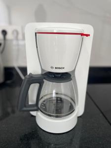 a white coffee maker sitting on top of a counter at Apartamento T1 - MedSal Residence in Santa Maria