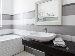 a white bathroom with a sink and a mirror at Andasì in Pachino