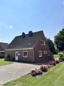 a large red brick house with a driveway at Ferienhaus Domizil Wattenmeer in Friedrichskoog