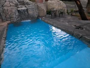 a pool of blue water with a chair in it at Pousada Flor de Pequi in Serra do Cipo