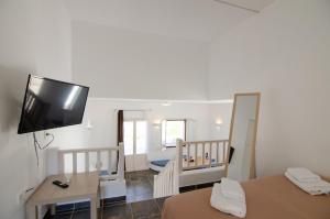 a room with two beds and a television on the wall at Mylopota apartment IIΙ in Mylopotas