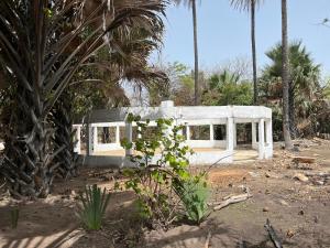 a white bench in a yard with palm trees at Tida-Ecolodge in Kartung +14 photos