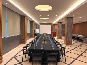 a conference room with a long table with chairs and a whiteboard at Royal Grand Hotel in Monrovia