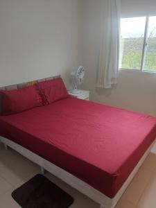 a bedroom with a large red bed with a window at Residência completa e com garagem in Garanhuns