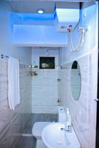 a white bathroom with a sink and a toilet at Paki hotels moshi in Msaranga