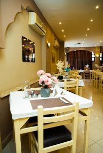 a dining room with a table with flowers on it at Golden Sun Hotel - Hurghada in Hurghada