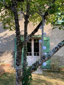 a house with a white door and a tree at Gîte de Lafeuillade in Montech