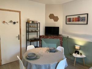 a dining room with a table and chairs and a television at Gîte de Lafeuillade in Montech