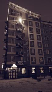 a tall building with lights on it at night at AMBER Hotel & Cafe in Bohorodchany