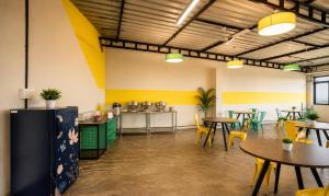 a restaurant with tables and chairs in a room at Hotel Vijaya Suites in Manipal +14 photos