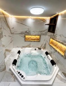 a bathroom with a jacuzzi tub in a marble wall at Solar de Pipa Vip Confort - Spa Hidro Flat in Pipa