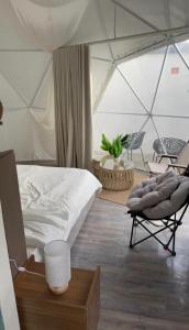a bedroom with a tent with a bed and a chair at سكون in Al Baha