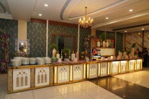 a restaurant with a counter with dishes on it at Crystal Park Hotel And Restaurant in Lalru