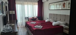a bedroom with a red bed with shoes on it at Villa Malezan in Ohrid