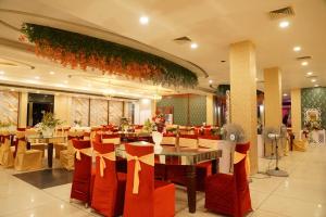 a restaurant with red chairs and tables in a room at Crystal Park Hotel And Restaurant in Lalru