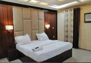 a bedroom with a large white bed in a room at Six Diamond Hotel in Ikeja +7 photos