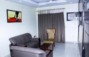 a living room with a couch and a chair at Six Diamond Hotel in Ikeja