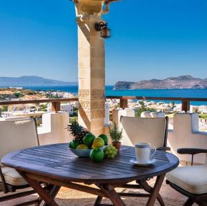 a bowl of fruit on a wooden table on a balcony at Thodorou Sunset Villa in Stalos