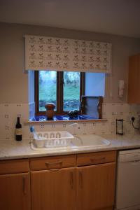a kitchen with a sink and a window at Shegarton Farm Cottages in Luss