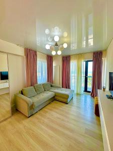 a large living room with a couch and a television at Summerland Seaview Premium Apartments in Mamaia