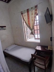 a small bedroom with a bed and a window at Lamu Sunsail Hotel in Lamu