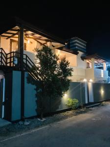 a white house with a tree in front of it at night at My Place Sri Lanka CMB Near Airport in Katunayaka